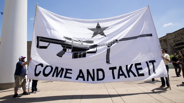 Demonstrators hold a large banner that reads "Come And Take It," during a pro-gun rally on the sidelines of the National Rifle Association (NRA) annual meeting in Dallas, Texas.