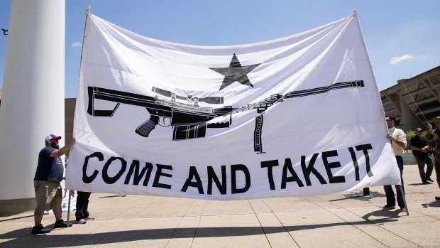 Demonstrators hold a large banner that reads "Come And Take It," during a pro-gun rally on the sidelines of the National Rifle Association (NRA) annual meeting in Dallas, Texas.