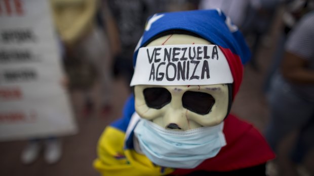 A woman with a message on her forehead reading 'Venezuela agonises' at an anti-government rally ahead of Sunday's poll.
