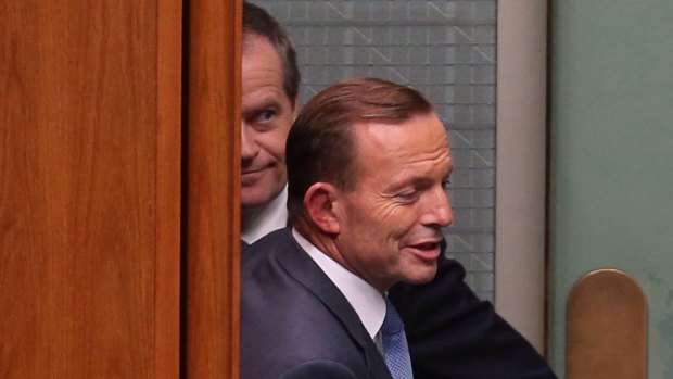 Prime Minister Tony Abbott and Communications Minister Malcolm Turnbull pass Opposition leader Bill Shorten behind the Speaker's chair during a division during question time on Thursday.