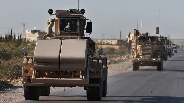 A US mine detector armored vehicle leads a convoy of US troops on a road leading to the tense front line with Turkish-backed fighters in Manbij town, Syria.