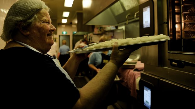 CWA volunteer Dianne Innes puts a tray of scones into the oven to cook for 16 minutes in the kitchen of the CWA tea room at the Sydney Royal Easter Show.