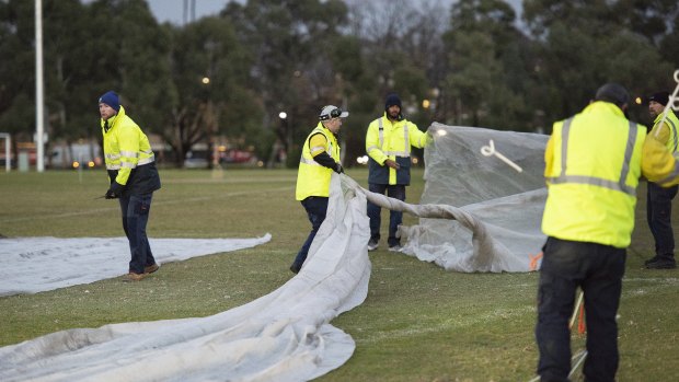 Council workers cover up graffiti painted at the memorial site of Melbourne comedian Eurydice Dixon.