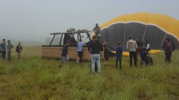 Flight gone wrong: Tourists surround the hot air balloon after a crash landing in a paddock at Pokolbin.