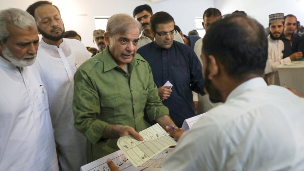 Shehbaz Sharif, president of the Pakistan Muslim League-Nawaz, receives his ballot at a polling station in Lahore.