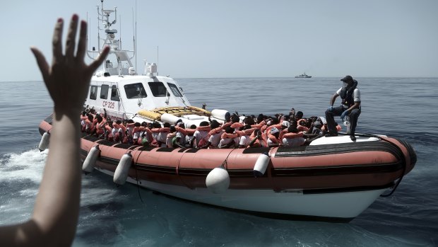 Migrants board an Italian Coast Guard ship after being transferred from the Aquarius to be taken to Spain on Tuesday.