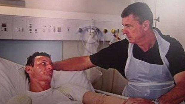 Police Commissioner Karl O'Callaghan comforts his son Russell during his stay in hospital after suffering injuries in a drug lab blast. Photo: Channel Ten.