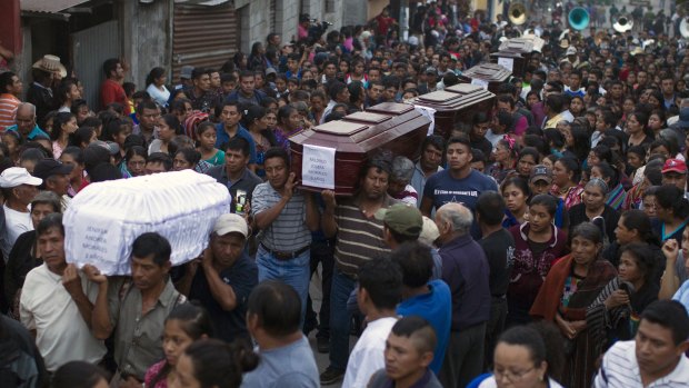 People carry the coffins of seven victims to the cemetery in San Juan Alotenango, Guatemala, on Monday.