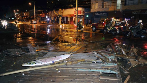 Police patrol a debris strewn street in Valparaiso, Chile, after a tsunami, caused by the earthquake. 