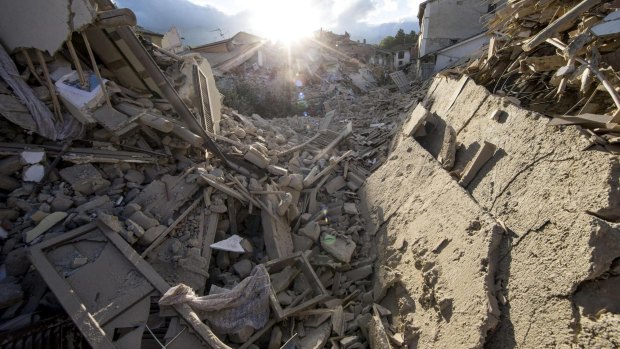 The sun rises over collapsed buildings following an earthquake in Amatrice, central Italy.