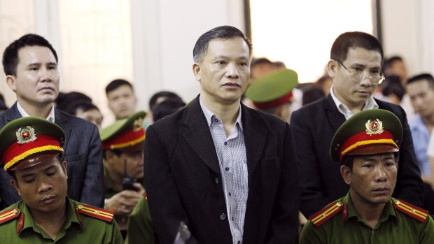 Prominent human rights lawyer Nguyen Van Dai, centre, stands trial in Hanoi, Vietnam.