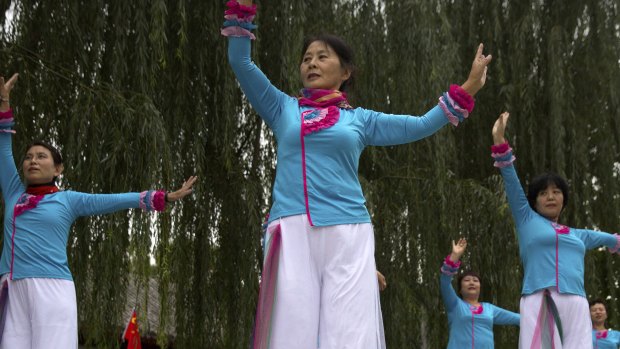 Women practice a dance routine outside residential community meeting during a media tour highlighting the Communist Party's efforts at the grassroots level in Beijing.