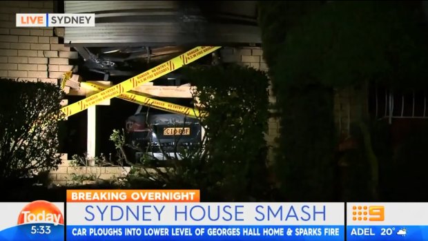 A 21-year-old has been arrested after allegedly crashing his car into a home in Sydney's south-west, causing it to burst into flames, police report. 