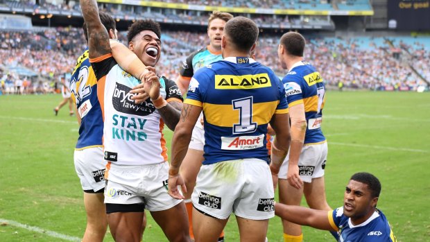 Flying high: Kevin Naiqama celebrates his try as the Wests Tigers beat Parramatta.