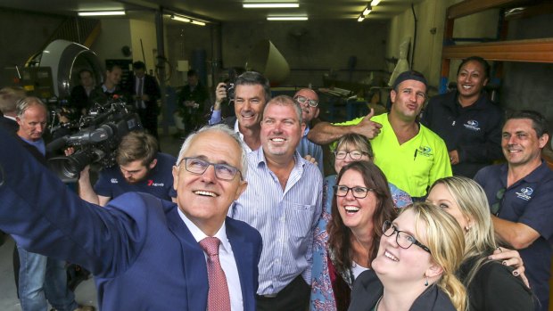 Malcolm Turnbull takes a selfie with workers during a tour of businesses alongside the LNP's candidate for Longman, Trevor Ruthenberg, in Caboolture.