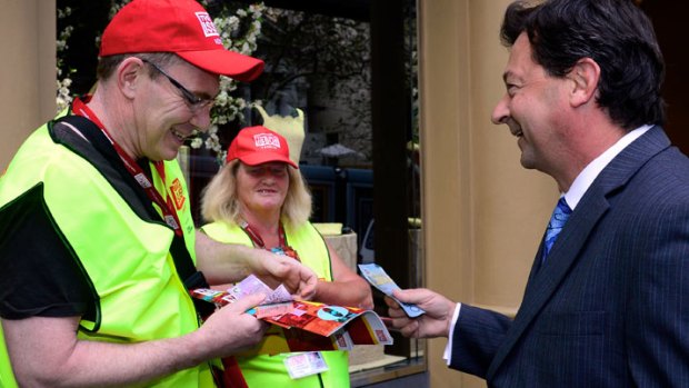 BHP Billiton CEO Andrew Mackenzie and Debra Merigan selling The Big Issue outside BHP's Collins Street offices in Melbourne to Rio Tinto managing director David Peever.