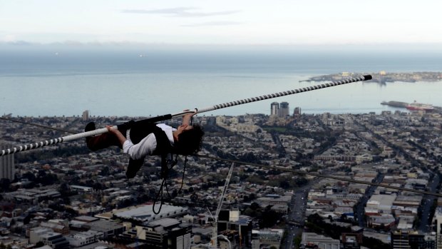 High wire artist Kane Petersen takes a breather and lies down on his 21 metre tightrope walk, 300m above the ground across the Eureka Tower's Skydeck. 