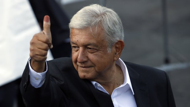 Presidential candidate Andres Manuel Lopez Obrador holds up his ink-stained finger.
