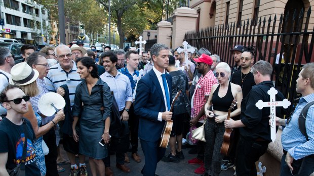 A protester holds a "R.I.P. Live Music" sign at the NSW Parliament to protest the closure of famed live music venue The Basement. 