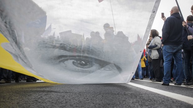 Protesters hold a poster depicting Oleg Sentsov during an opposition rally organised by  'Free Russia' in Moscow.