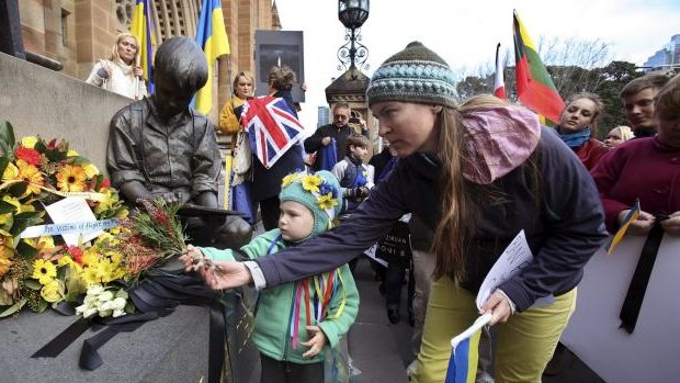 Ukrainian Community placing a reef of flowers and black ribbons at the Mary MacKillop Memorial, St Mary Cathedral in Sydney.