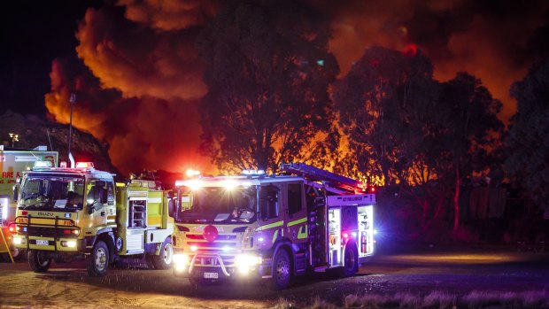 Emergency services work to put out a fire at a scrap yard in the industrial suburb of Beard, Queanbeyan, on Sunday night. 