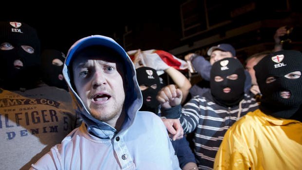 Members of the English Defence League (EDL) wear balaclavas as they gather outside a pub in Woolwich in London.