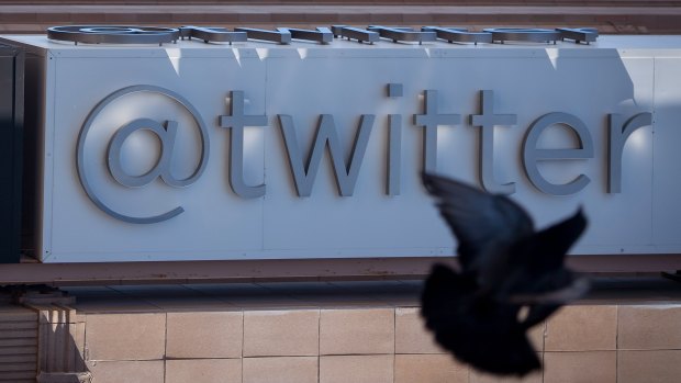 A bird flies past Twitter Inc. signage displayed outside the company's headquarters in San Francisco, California.