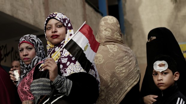 Women wait in line to vote outside a polling station at a school in Giza.