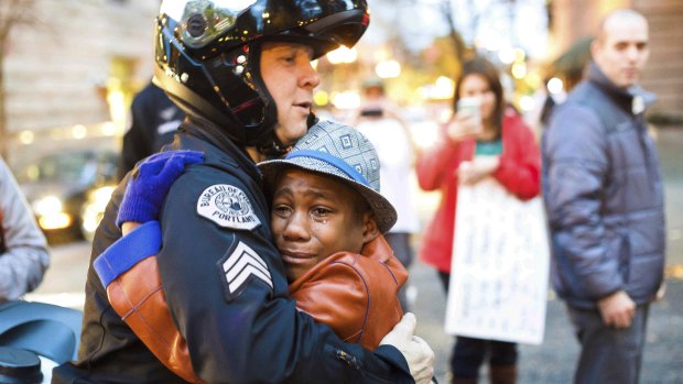 Portland police Sergeant Bret Barnum, left, and Devonte Hart, 12, hug at a rally in Portland, Oregon where people had gathered in support of the protests in Ferguson, Missouri.