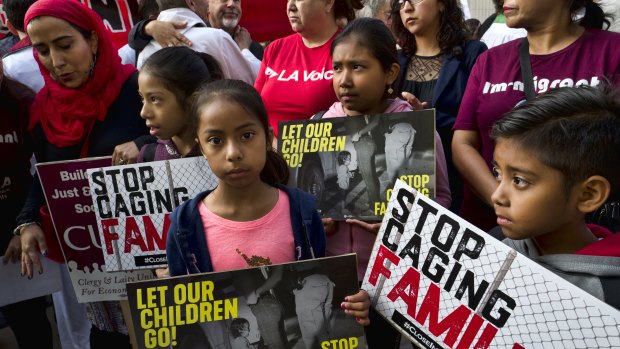 Children stand and hold protest signs at a rally in front of Federal Courthouse in Los Angeles on Tuesday.