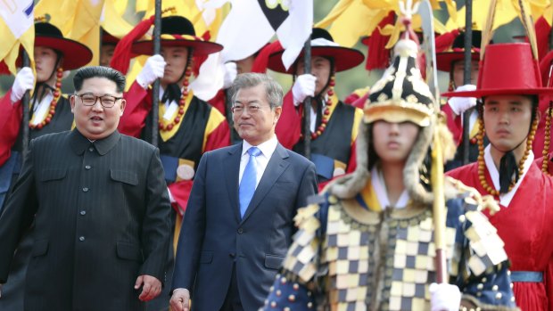 North Korean leader Kim Jong-un, left, and South Korean President Moon Jae-in, right, walk together through a honour guard.