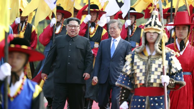 North Korean leader Kim Jong-un, left, and South Korean President Moon Jae-in, right, walk together through a honour guard.