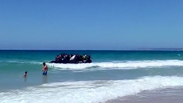A rubber dingy carrying migrants approaches the beach at Cadiz, southern Spain last year. 