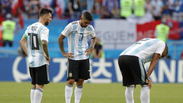 Lionel Messi, left, Ever Banega, center and Gabriel Mercado stand dejected after being eliminated from the World Cup.