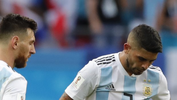 Lionel Messi, left, Ever Banega, center and Gabriel Mercado stand dejected after being eliminated from the World Cup.