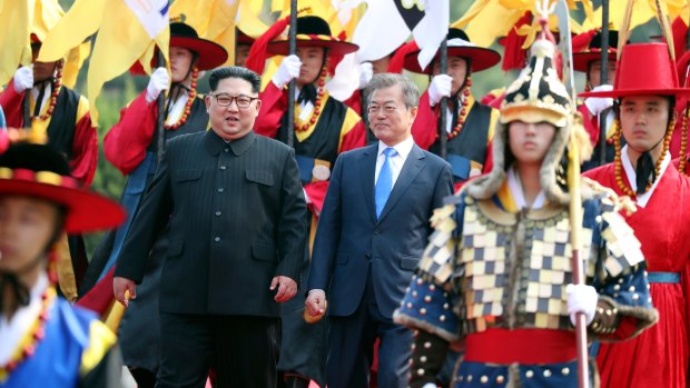 North Korean leader Kim Jong-un, left, and South Korean President Moon Jae-in walk together through a honour guard at the border village of Panmunjom in the Demilitarised Zone. 