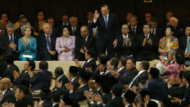 Prime Minister Tony Abbott waves after being acknowledged during the inauguration ceremony of Indonesian President Joko Widodo in Jakarta on Monday.