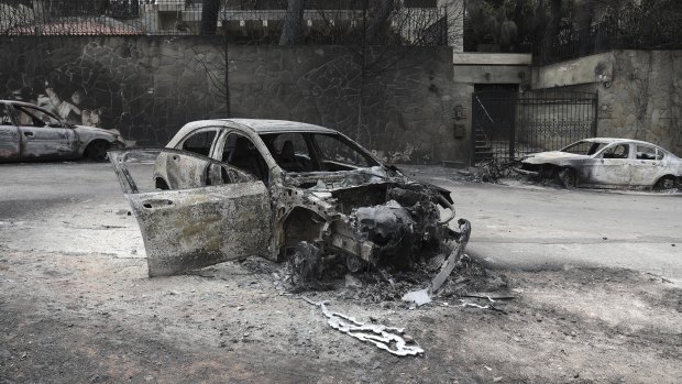 Cars were destroyed by the wildfires near the village of Neos Voutzas near Athens.