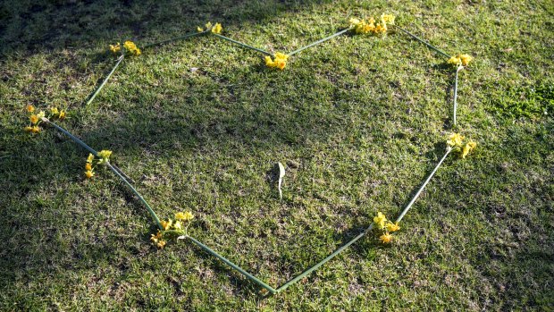 A heart-shaped chain of yellow and orange jonquils at the scene of the woman's death in Princes Park.