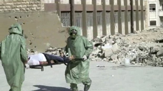 Syrians in protective suits and gas masks conduct a drill on how to treat casualties of a chemical weapons attack in Aleppo in 2013.