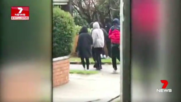 A group of youths leave the house in Carnegie after police arrive. 