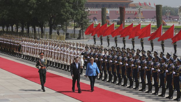 Chinese Premier Li Keqiang escorts  German Chancellor Angela Merkel past the People's Liberation Army honour guards to welcome her to China on Thursday.