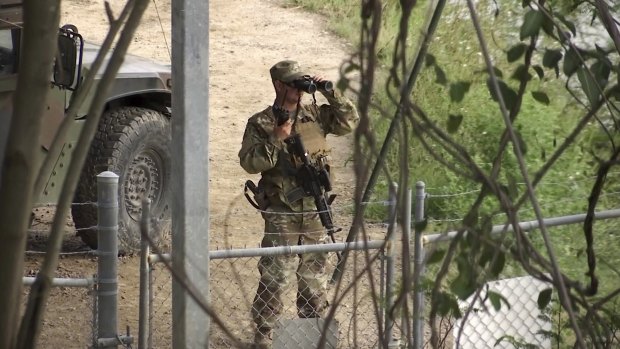 A National Guard troop watches over Rio Grande River on the US-Mexico border in Roma, Texas. 
