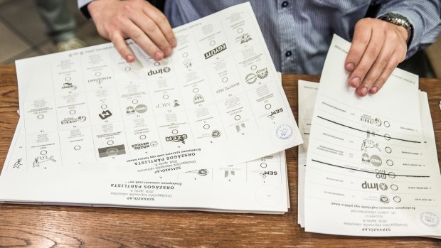 An electoral official handles voting information at a polling station in Budapest, Hungary.