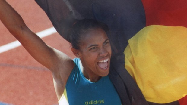 Cathy Freeman holds up the Aboriginal flag alongside the Australian flag after her 400m win at the 1994 Commonwealth Games.