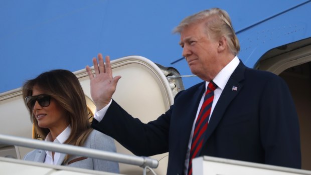 US President Donald Trump waves as he and his wife Melania arrive at the airport in Helsinki on Sunday.