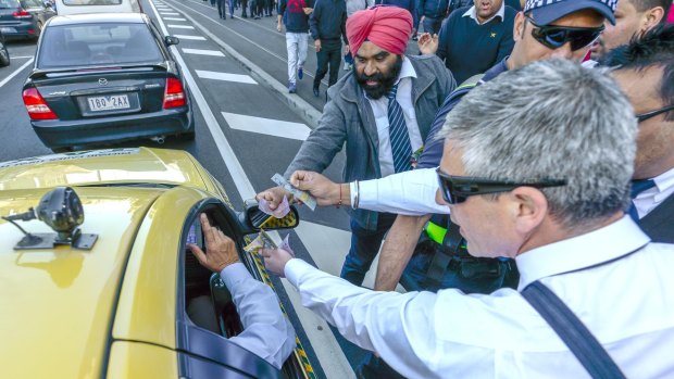 The Age, News, picture by Justin McManus 10/09/2015.Taxi Driver protest at Parliament house. Taxi drivers protesting over the Uber S App that they say is destroying their business. Protesting drivers offer money to a Taxi driver who is still working. a