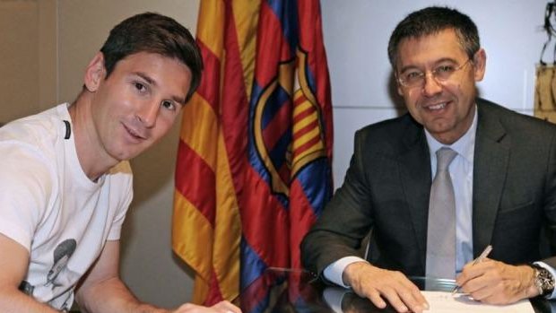 Barcelona's Lionel Messi (L) signing his new contract with the Catalan club with FC Barcelona's president Josep Maria Bartomeu.