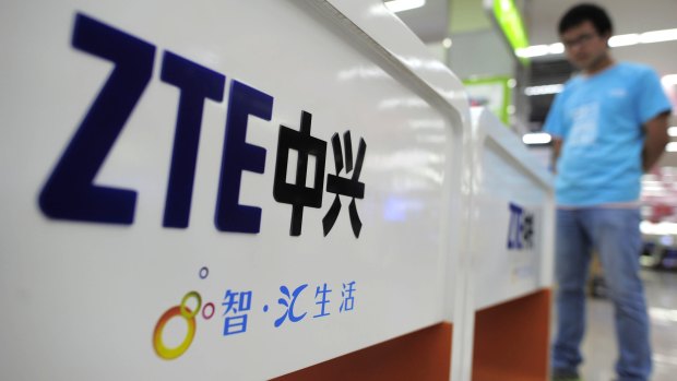 A salesperson stands at counters selling mobile phones produced by ZTE in China.